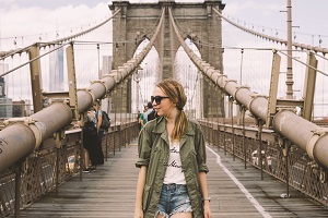 Topdeck traveler standing in the pedestrian lane of Brooklyn bridge.