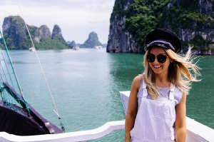 Topdeck traveler posing for a photo on a boat cruising through Vietnam's awe-inspiring Halong Bay.