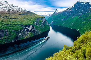 A boat cruising up the famous Geirangerfjord in Norway.