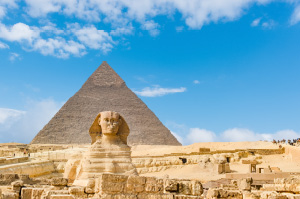 The famous statue of the Sphinx with on of the Pyramids of Giza in the background.