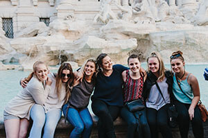 Group of Topdeck travelers posing for a photo in front of Rome's famous Trevi Fountain.