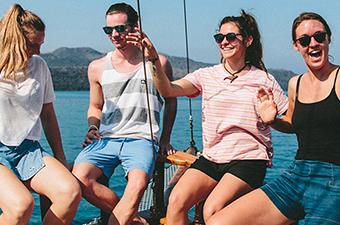 4 Topdeck travelers on boat in European sea.