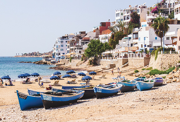 Fishing boats resting on the sandy beach of Taghazout.