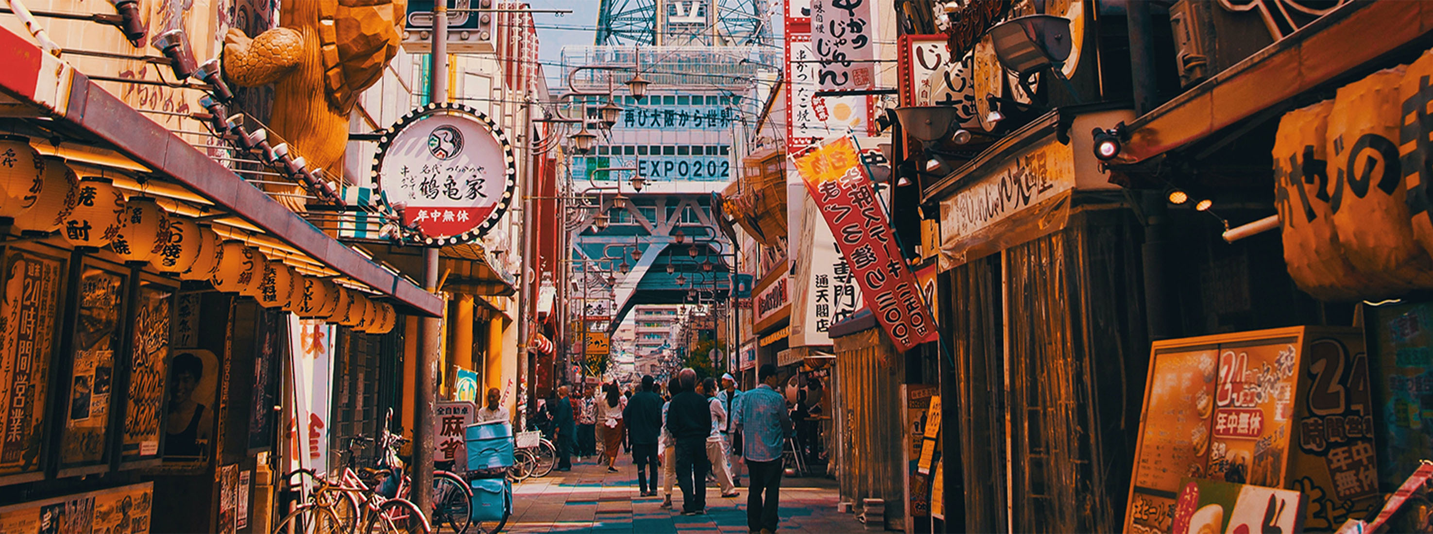Advertisements for izakayas and bars adorn the busy Osaka street.