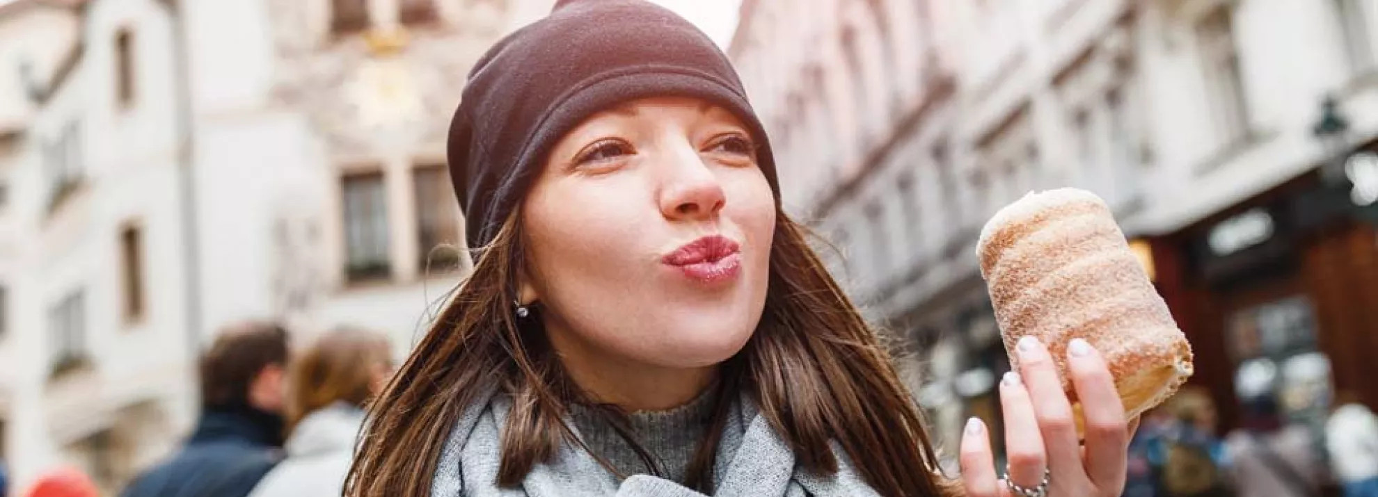 A woman eating a sugary pastry 