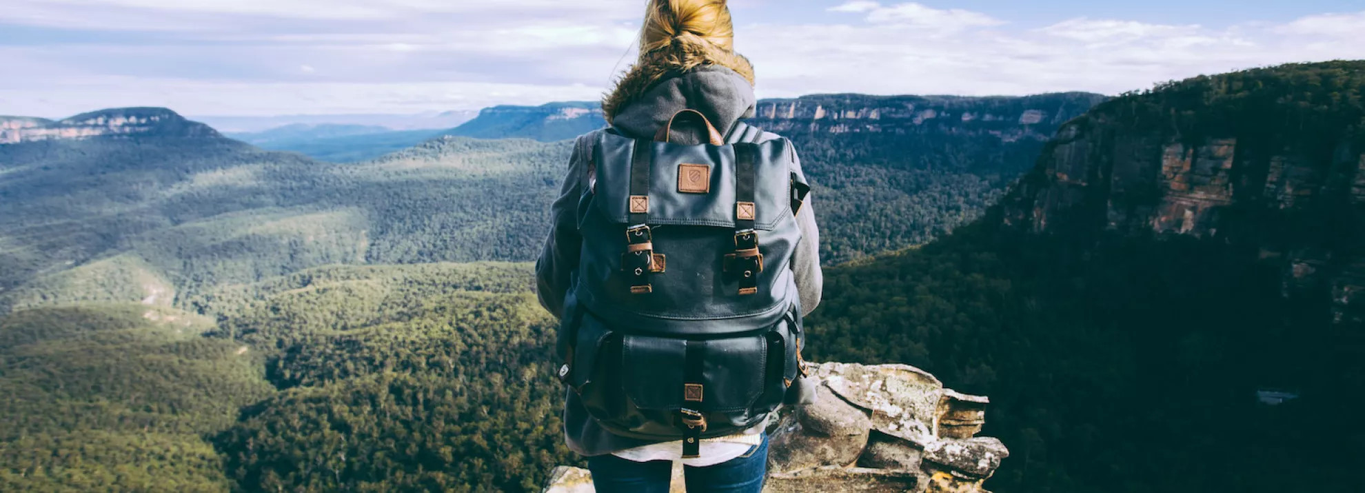 woman with back to camera staring out to the mountains