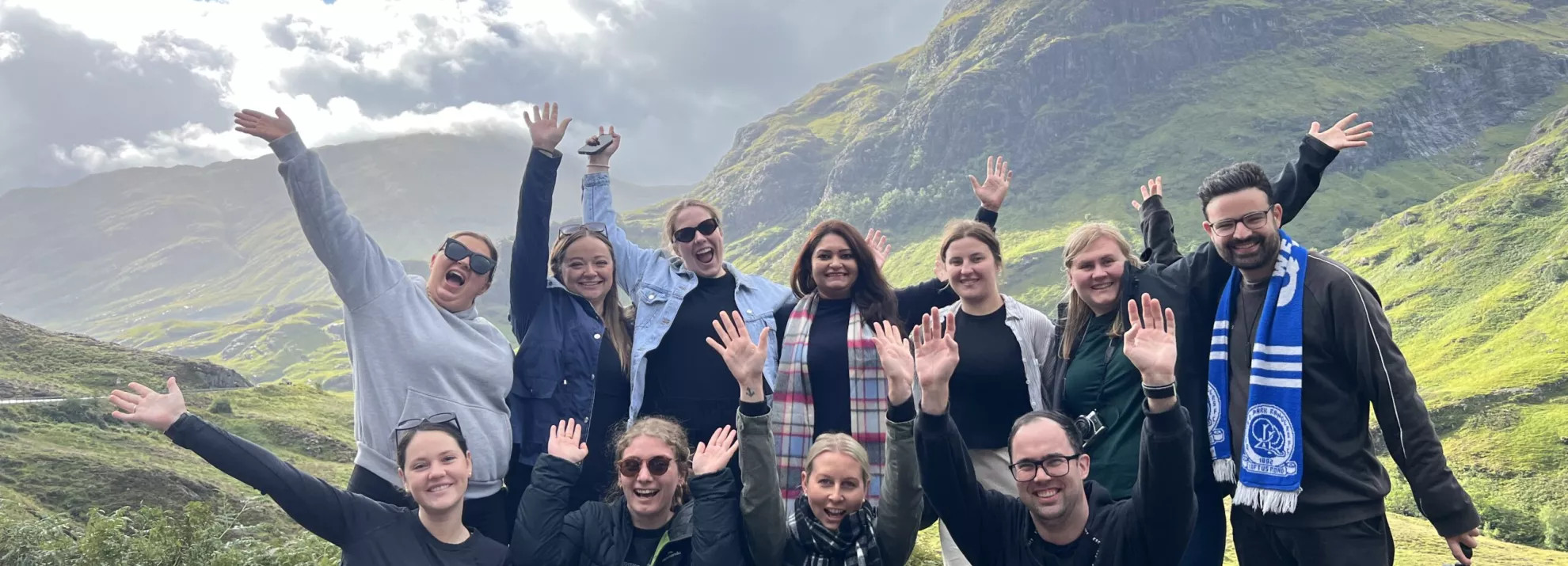 topdeckers on a mountain with their hands up