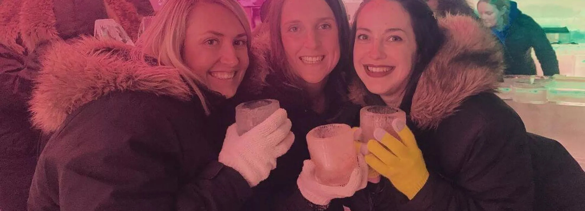 Three people smiling holding mugs