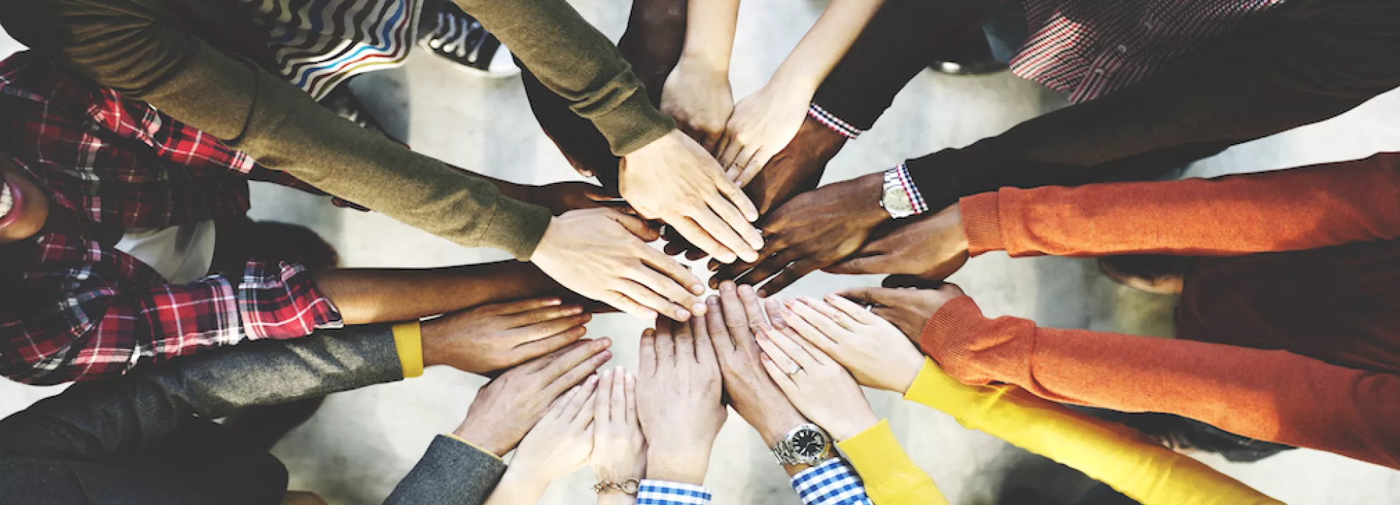many hands together in the middle forming a circle