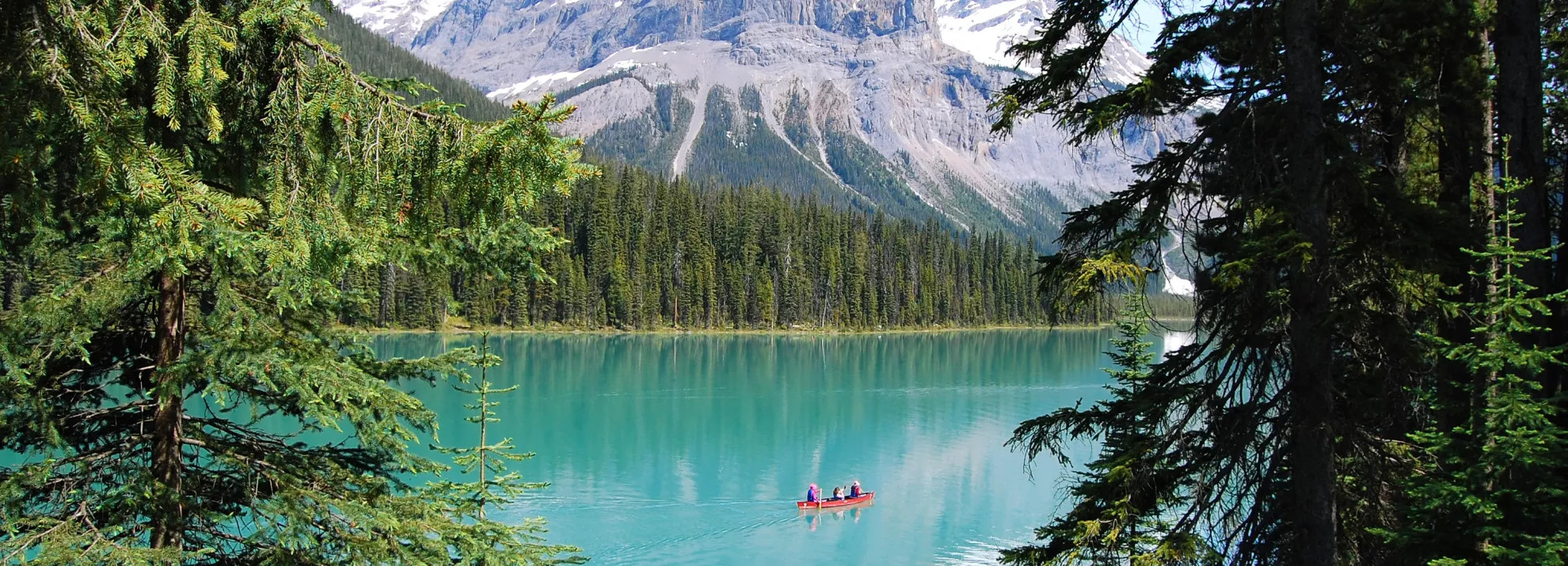A canoe on Emerald Lake with mountains in the back