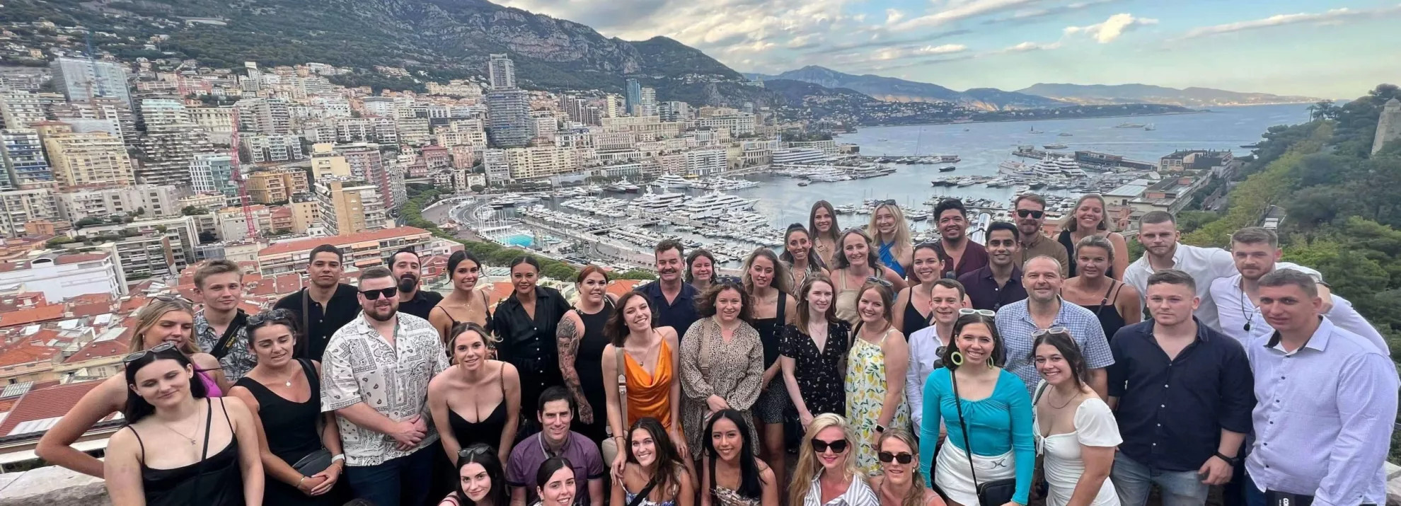 A large group of topdeckers with the cityscape and beach behind them