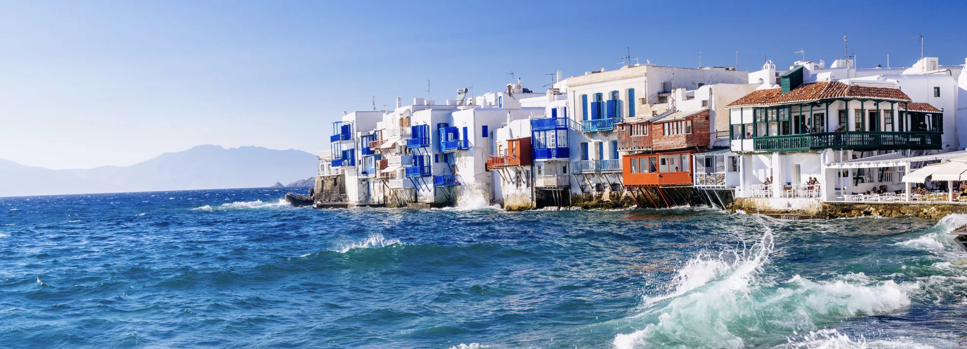 White, blue and orange houses by the sea in Greece