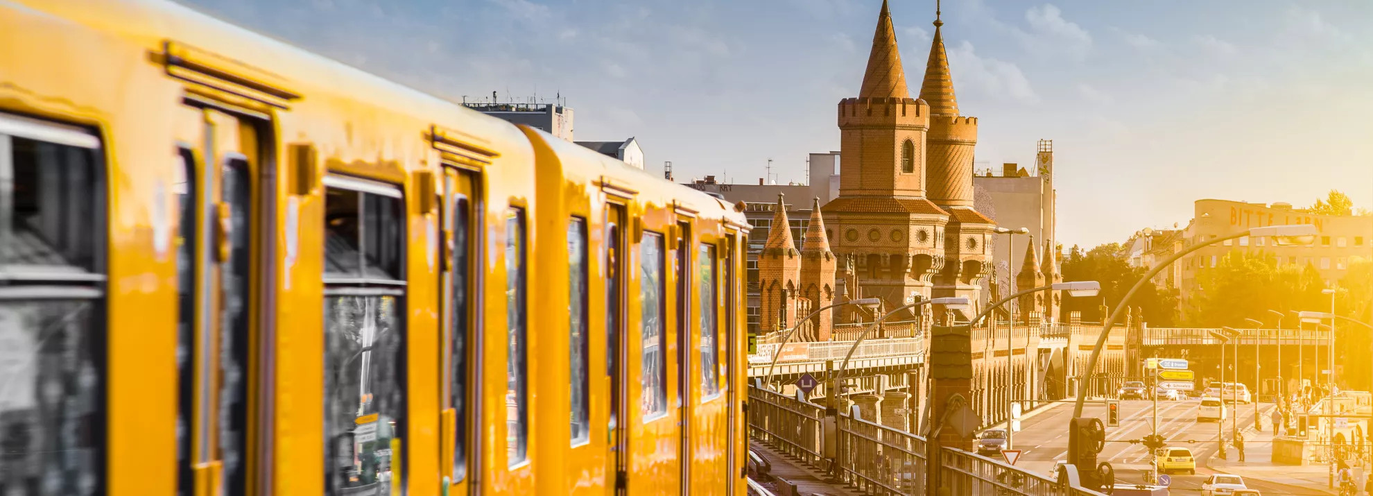 A yellow train drives over Berlin skyline