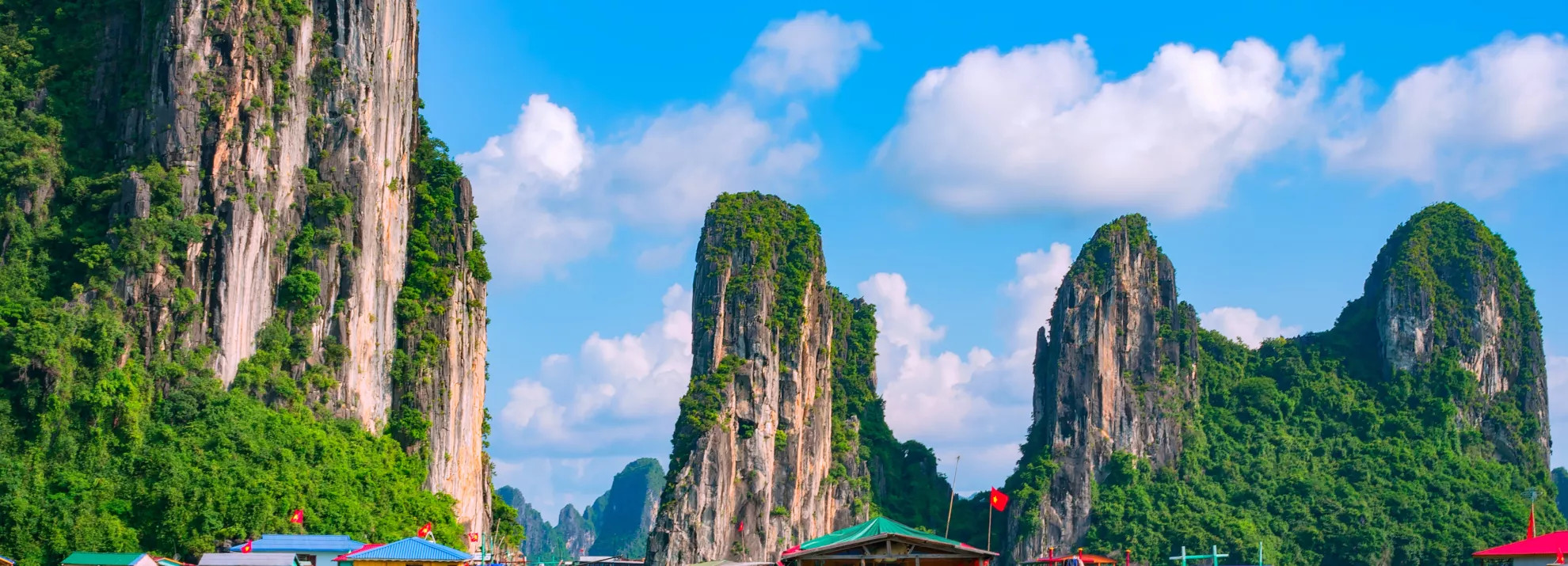Mountains surrounding a body of water with floating houses on them in Vietnam