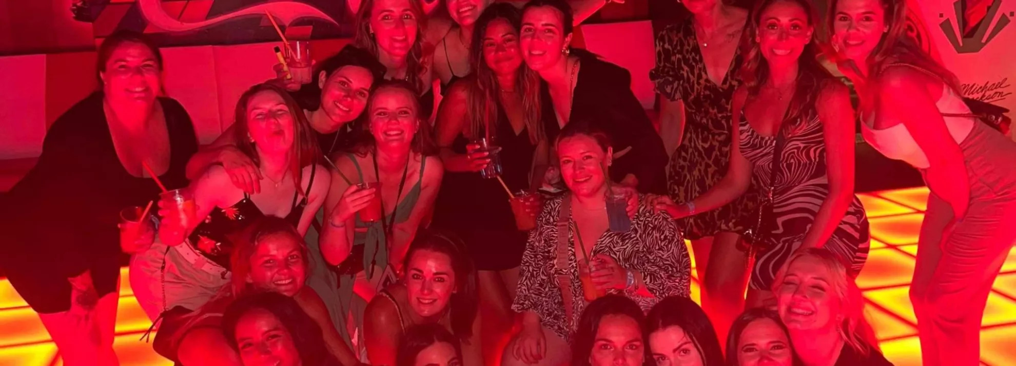 A group of topdeckers in a club lit up with red lights