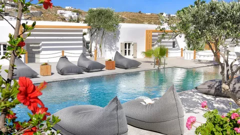 Stylish beanbags and bright white walls line the sparkling waters of a swimming pool in Pentinos.