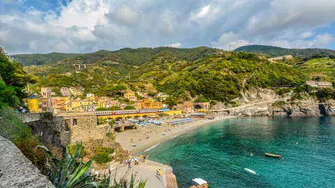 Yellow buildings next to the deep blue ocean in Monterosso al Mare in Cinque Terre.
