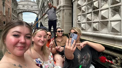 People taking a selfie on a gondola boat ride in Venice, Italy.