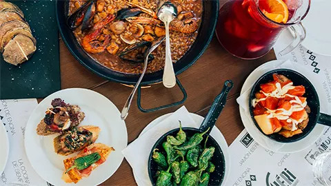 Spanish tapas and paella on a table.