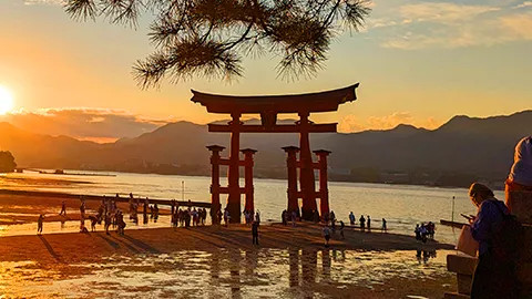 Floating torii gate of the Itsukushima Shrine on Miyajima Island at sunset.
