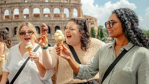 Three people eating gelato outside the Roman colosseum.