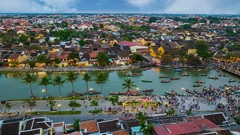 Houses along the Thu Bon River at night in Hoi An, Vietnam.