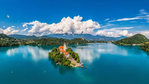 Church of Assumption sitting on a deep blue Lake Bled in Slovenia.