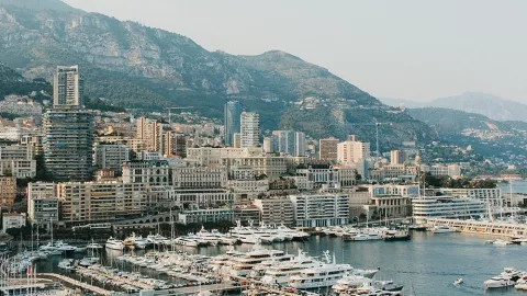 The tall buildings of Monte Carlo and its port filled with yachts in Monaco.