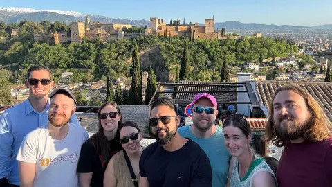 People standing together with the Alhambra complex in Granada, Spain, in the background.