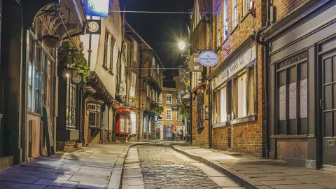 Streetlights shine on the old English stony streets of the Iconic Shambles in York.