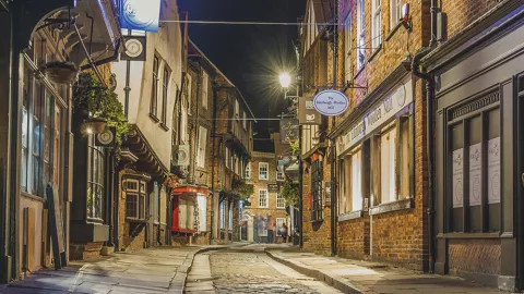 Empty street with traditional brick buildings in York at night.