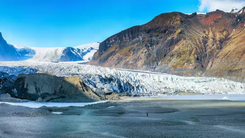 Skaftafellsjökull glacier against rocky hillside in Iceland.