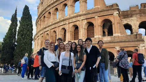 Group of people taking a photo in front of The Colosseum