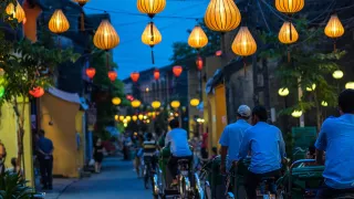 Locals cycle down the lantern lit streets of Hoi An in Vietnam.