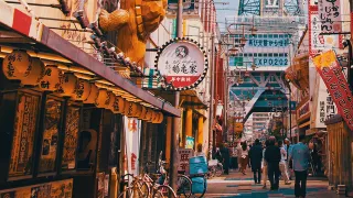Street view in Osaka, Japan with lanterns, flags and shop signs.