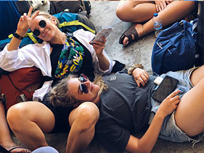 Topdeck travelers laying their heads on their luggage ready for the next leg of the tour.