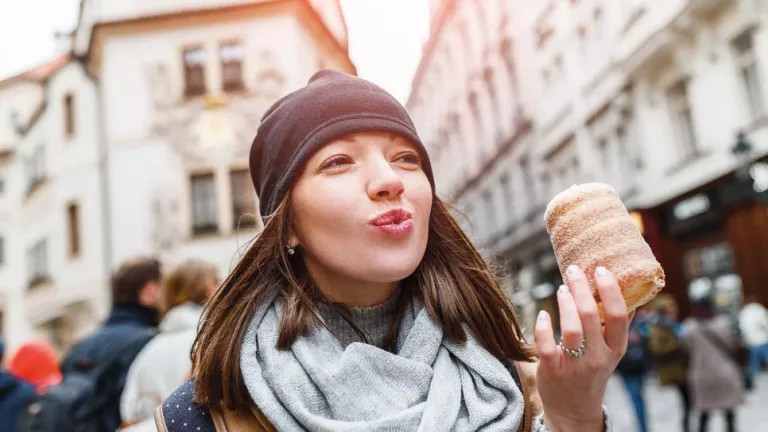 A woman eating a sugary pastry 