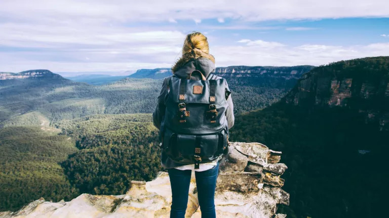woman with back to camera staring out to the mountains