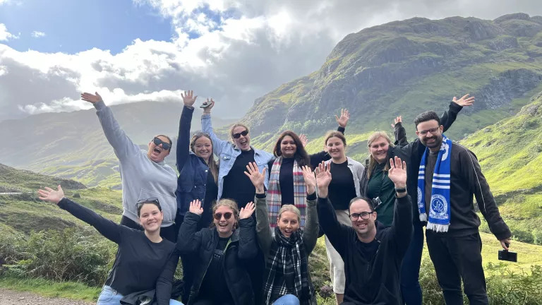 topdeckers on a mountain with their hands up