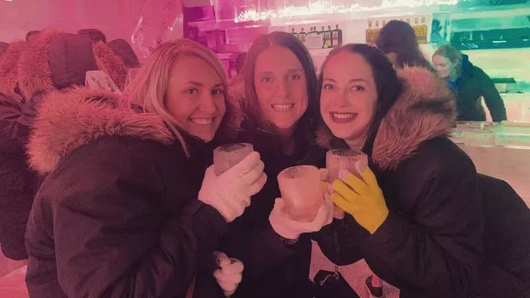 Three people smiling holding mugs
