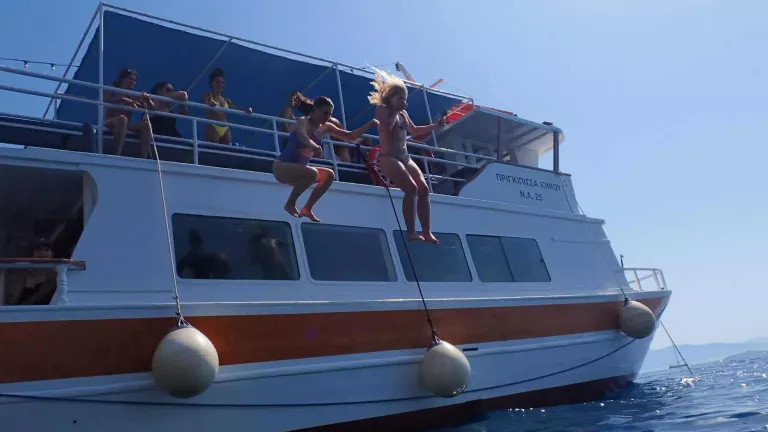 Two women jumping off a boat into the sea