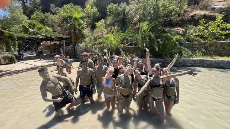 A group of topdeckers standing in a river with mud on them