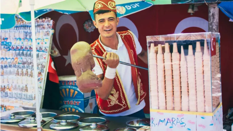 Man selling ice cream on a stick at a stand