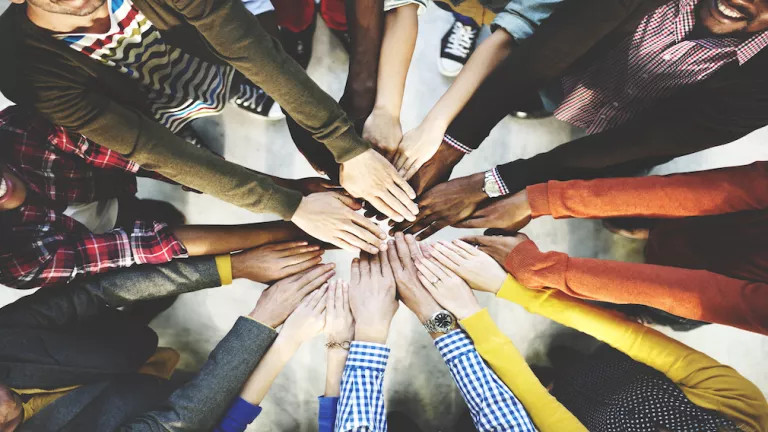 many hands together in the middle forming a circle
