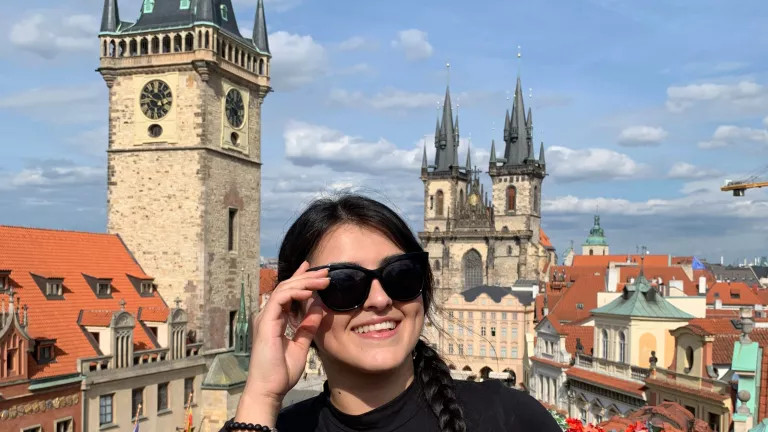 A woman wearing sunglasses with the city behind her