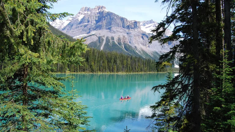 A canoe on Emerald Lake with mountains in the back