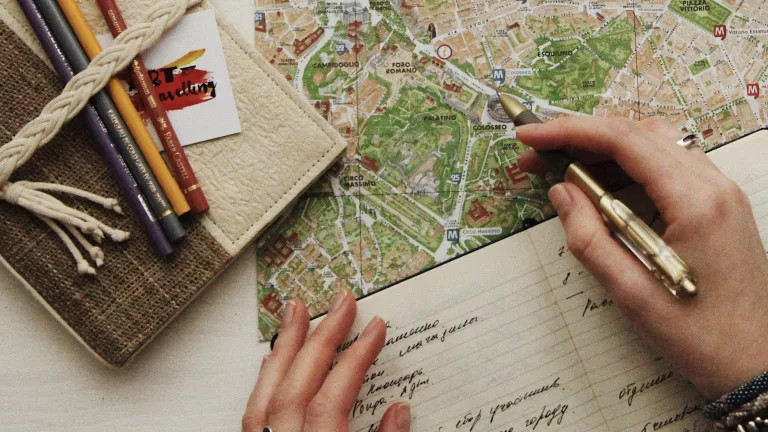 opened notebook with words on the page and a map on a table