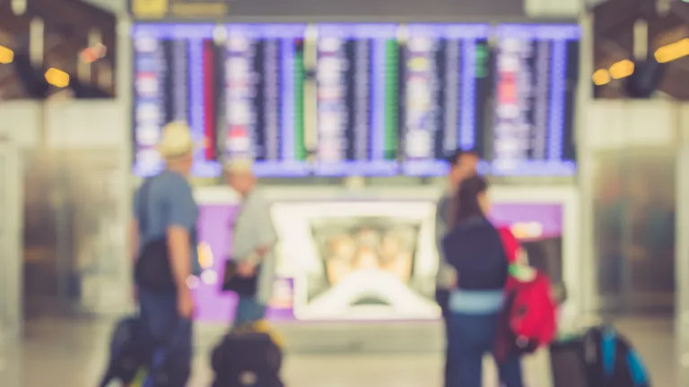 Blurry photo of an airport screen showing all the flights and their corresponding gates