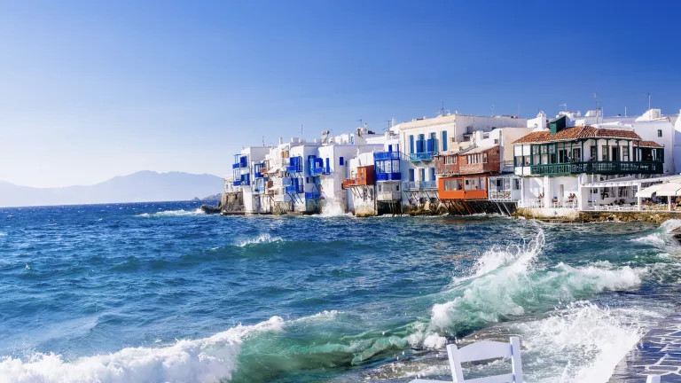 White, blue and orange houses by the sea in Greece