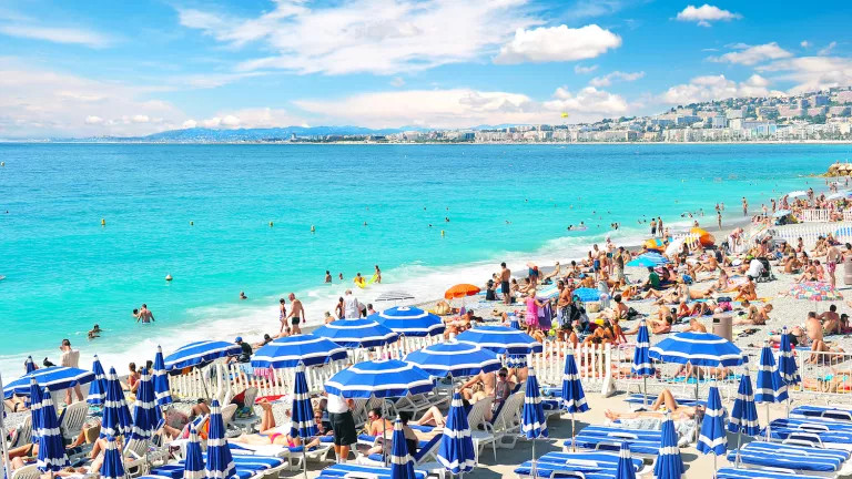 view of the beach with many sun loungers and umbrellas on it